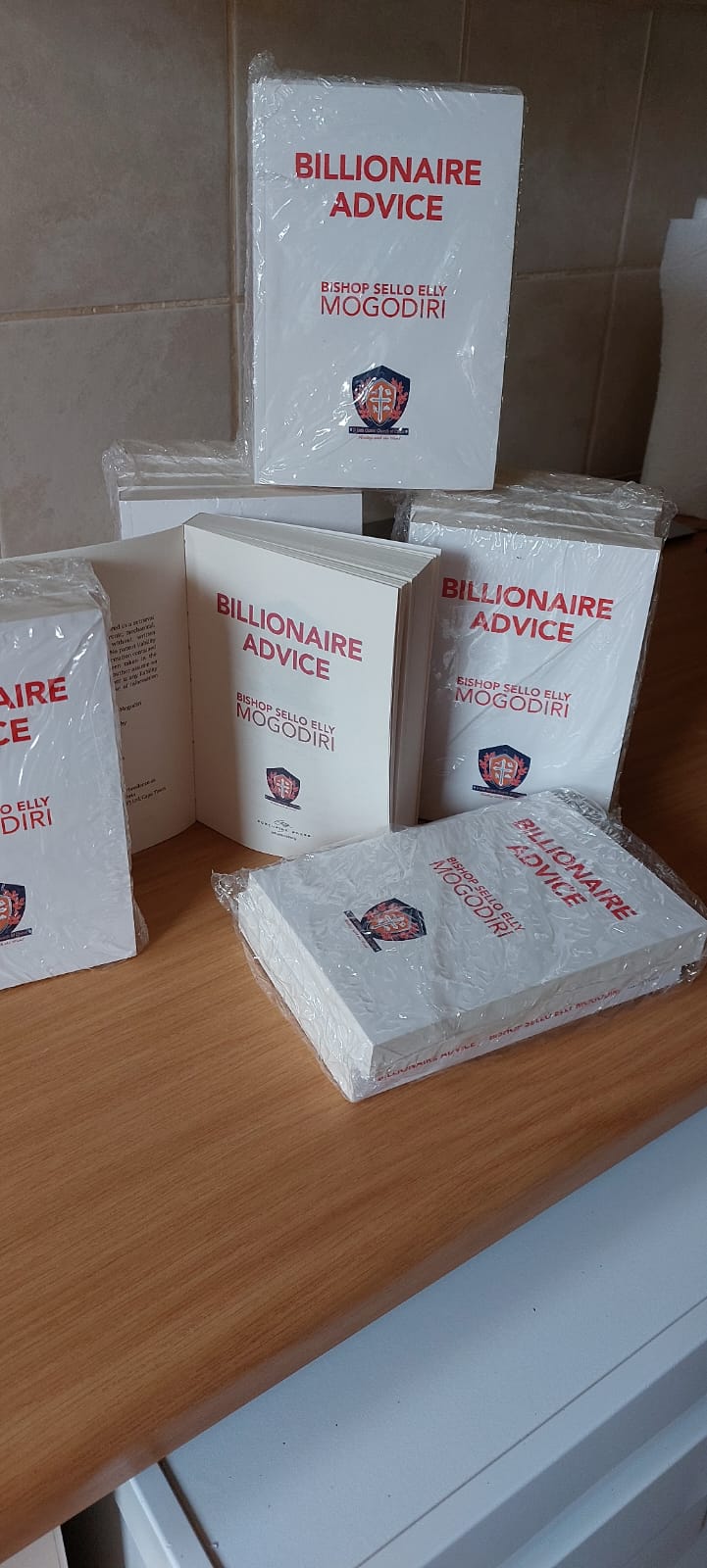 Stack of Billionaire Advice books by Bishop Sello Elly Mogodiri