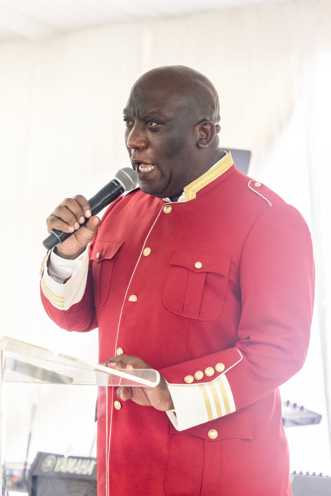 Bishop Mogodiri speaking passionately with a microphone in hand